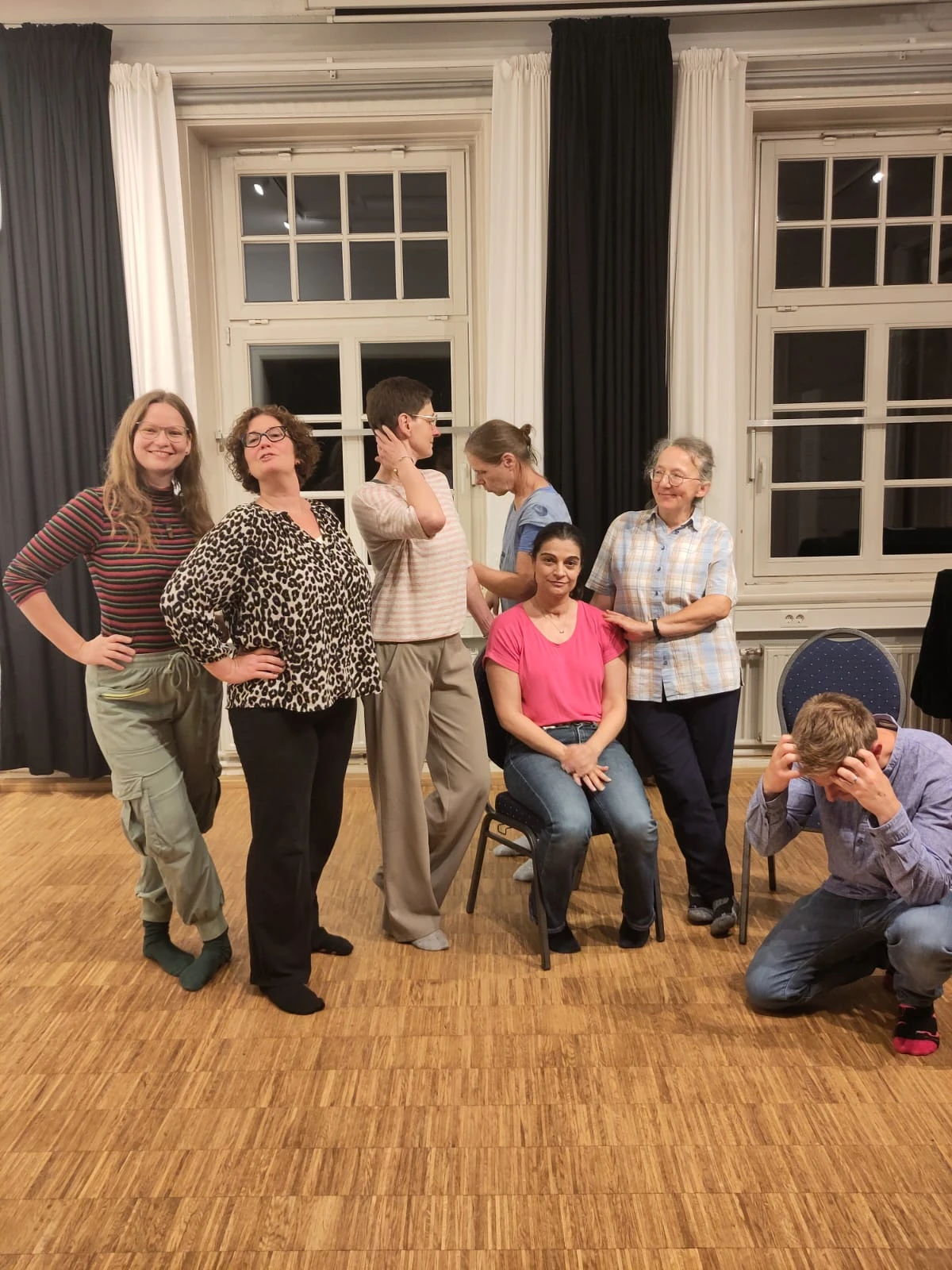 Die Gruppe des offenen Impro-Abends beim Status-Workshop mit Annette: sieben Menschen in Hoch- und Tiefstatus-Posen im Berenberg-Gossler-Haus